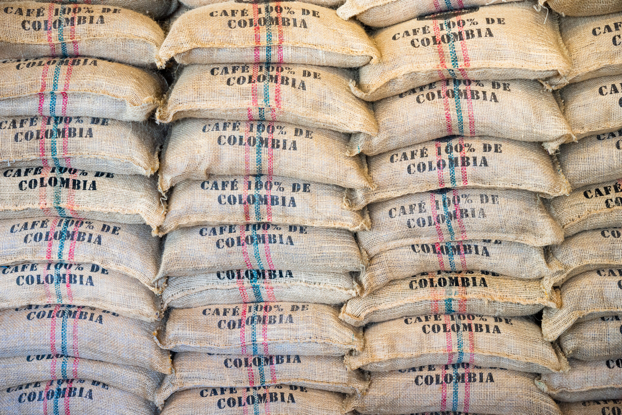 Stack of burlap sacks Colombia coffee, backdrop, template.